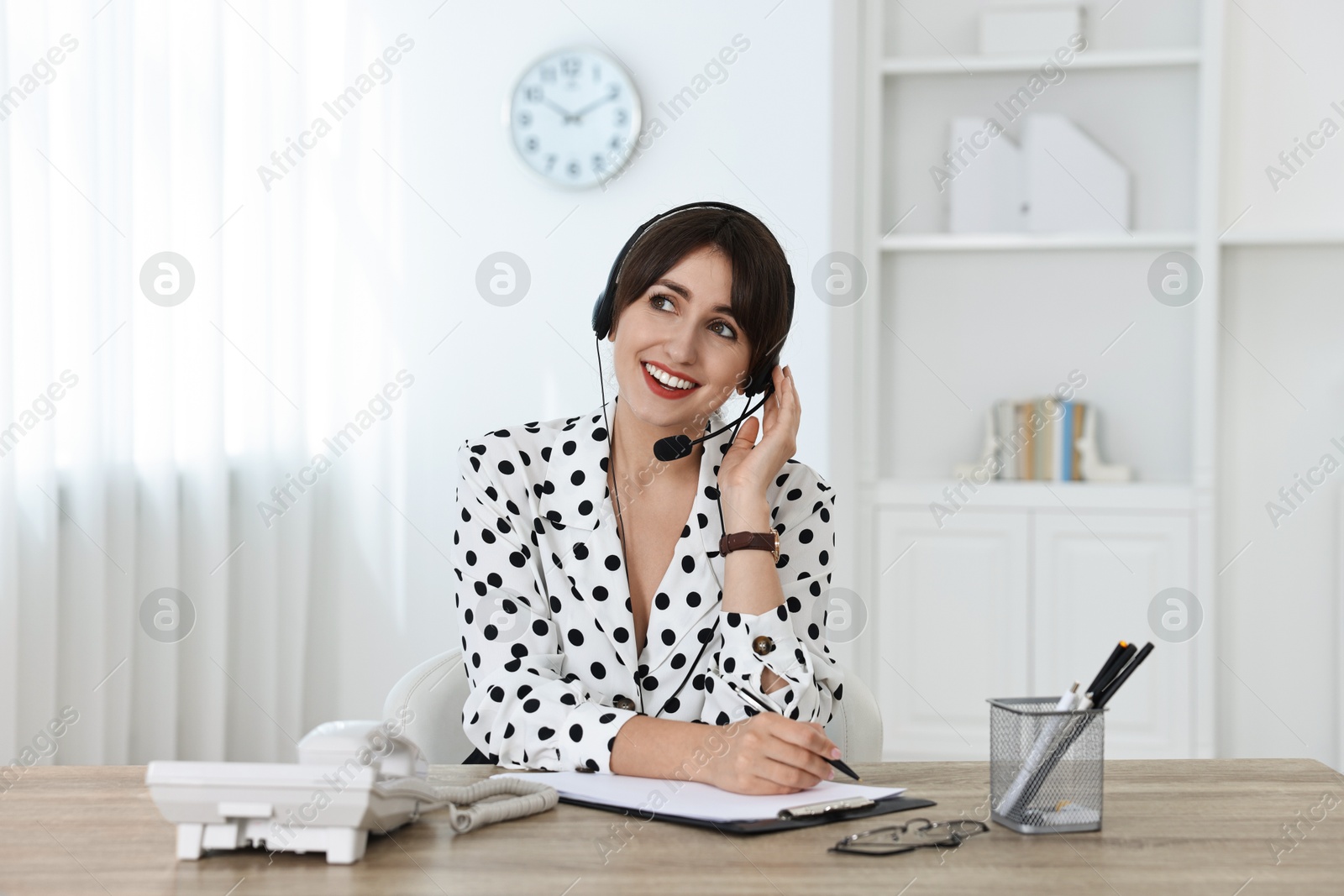 Photo of Professional receptionist working at wooden desk in office