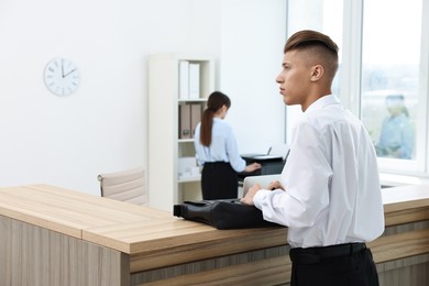 Photo of Professional receptionist and client in modern office