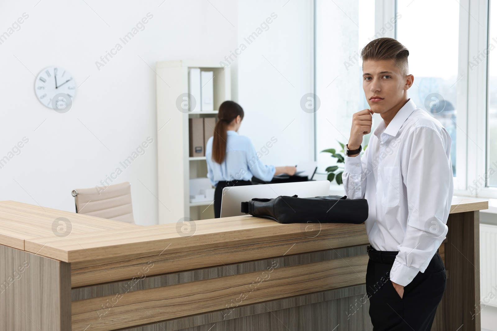 Photo of Professional receptionist and client in modern office