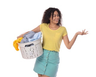 Happy woman with basket full of laundry on white background