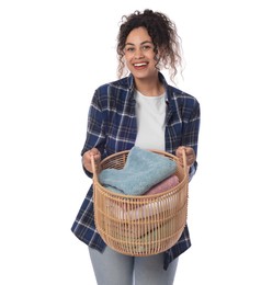 Happy woman with basket full of laundry on white background