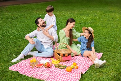 Happy family having picnic together in park