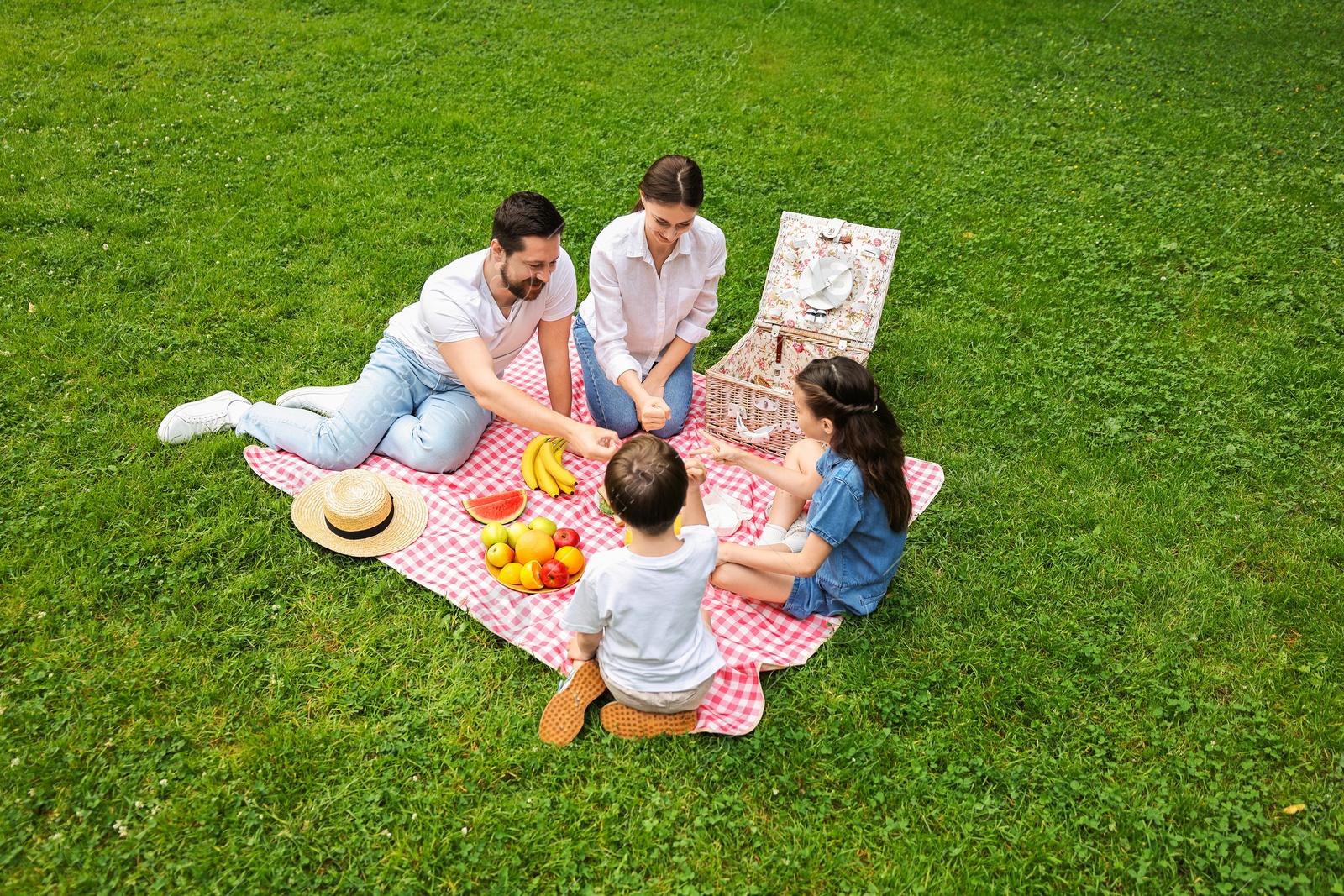 Photo of Family playing rock, paper and scissors during picnic outdoors