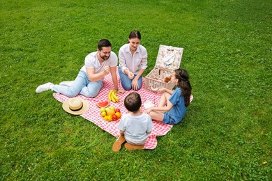 Photo of Family playing rock, paper and scissors during picnic outdoors