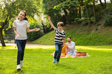 Happy children playing during family picnic outdoors