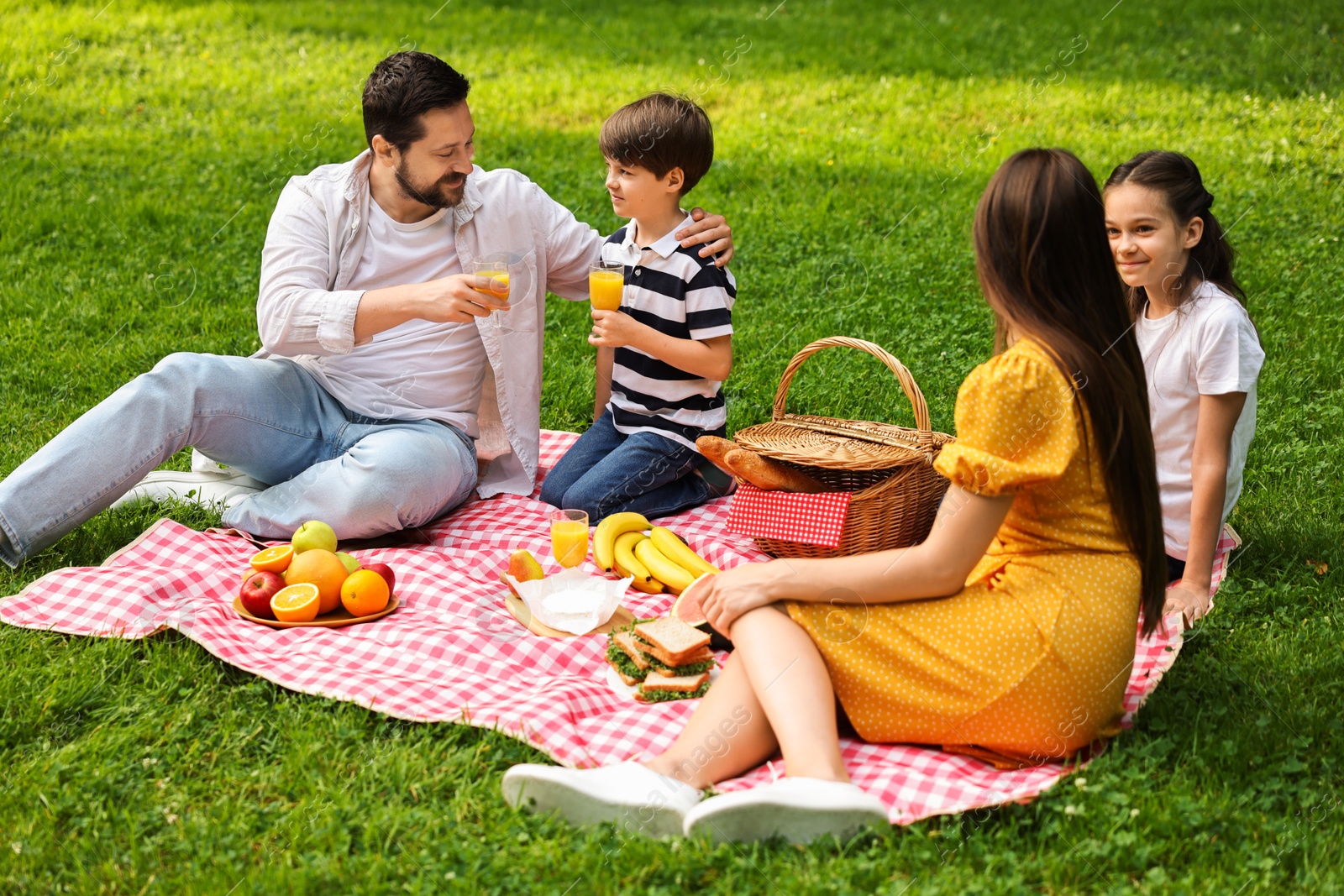 Photo of Family picnic. Parents and their children spending time together outdoors