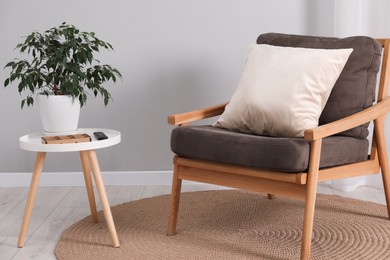 Soft pillow on armchair near coffee table indoors