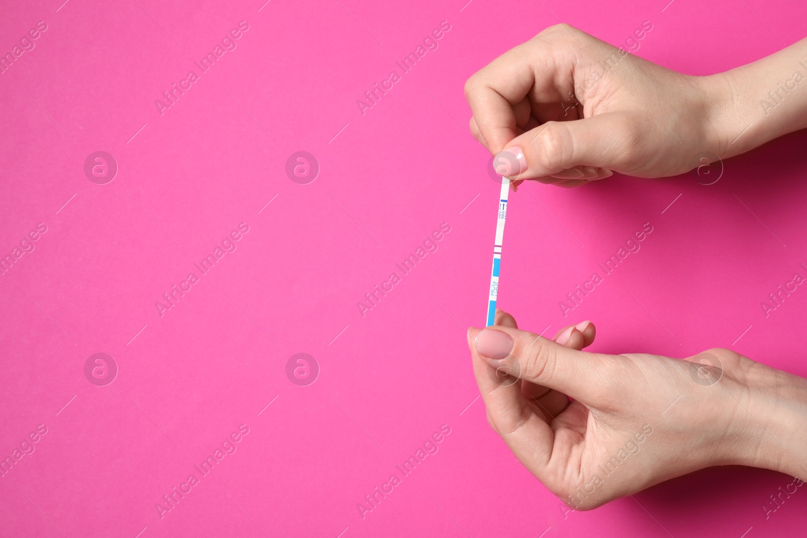 Photo of Woman holding pregnancy test on pink background, top view. Space for text