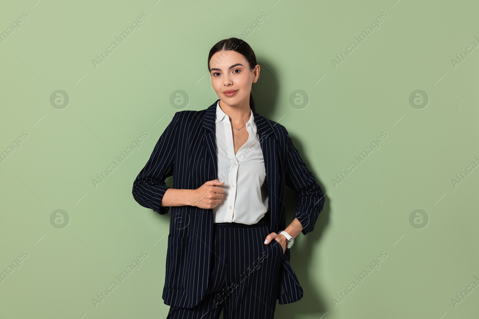 Photo of Beautiful woman in black striped suit on green background