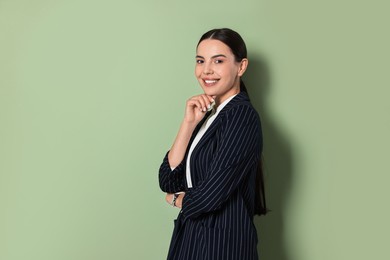 Photo of Beautiful woman in black striped suit on green background