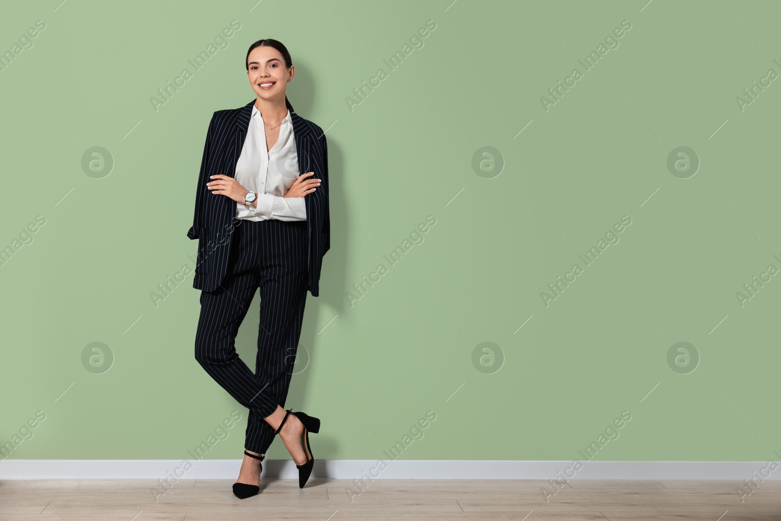 Photo of Beautiful woman in black striped suit indoors, space for text