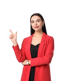 Beautiful woman in red jacket and black dress pointing at something on white background