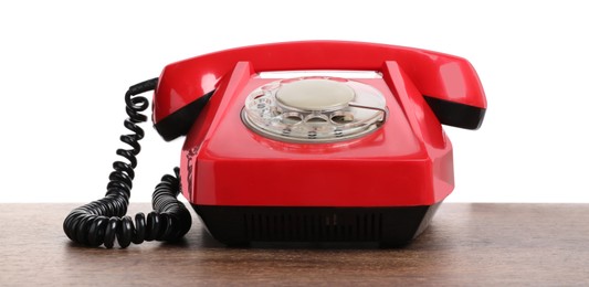 One red telephone with handset on wooden table against white background