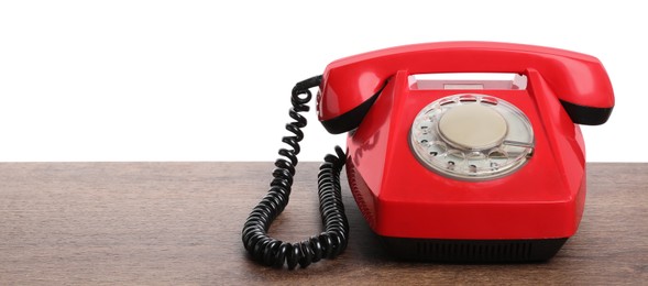 Photo of One red telephone with handset on wooden table against white background