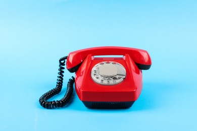 Photo of Red telephone with handset on light blue background