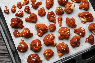 Photo of Tray with tasty cauliflower buffalo wings on wooden table, top view