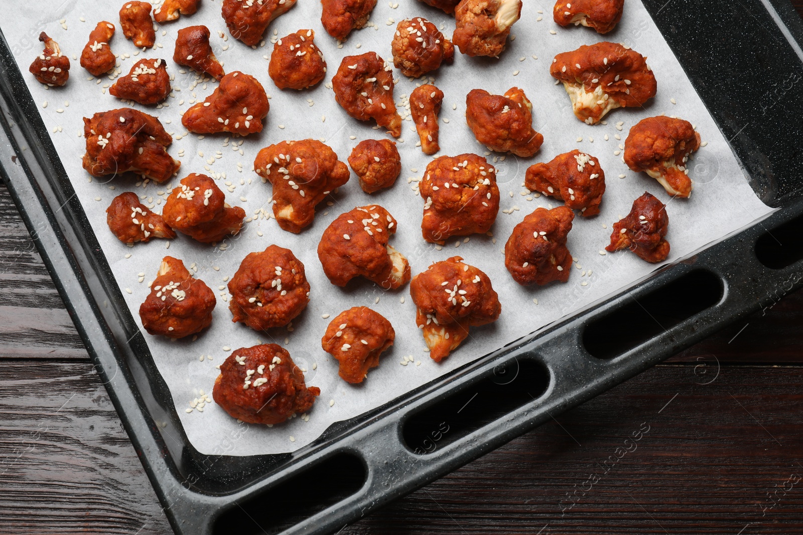 Photo of Tray with tasty cauliflower buffalo wings on wooden table, top view