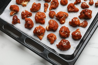 Photo of Tray with tasty cauliflower buffalo wings on white table, top view