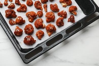 Photo of Tray with tasty cauliflower buffalo wings on white table, top view