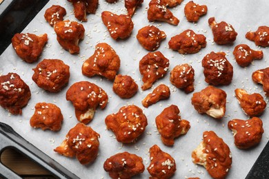 Photo of Tray with tasty cauliflower buffalo wings on wooden table, top view