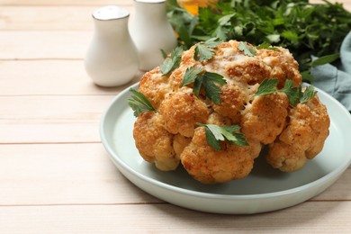 Delicious baked cauliflower with parsley on wooden table, closeup