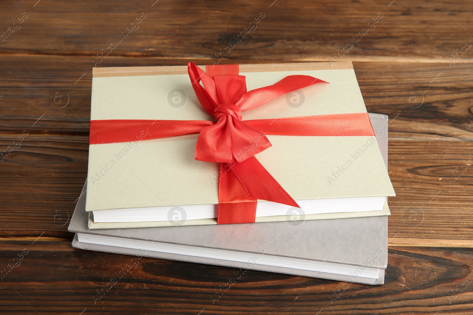 Photo of Books with ribbon as gift on wooden table