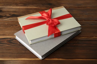 Photo of Books with ribbon as gift on wooden table