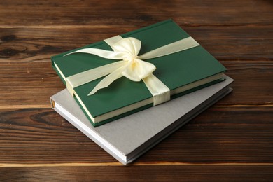 Photo of Books with ribbon as gift on wooden table