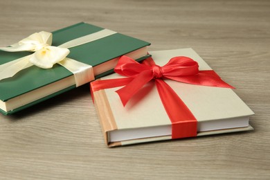 Photo of Books with ribbons as gift on wooden table