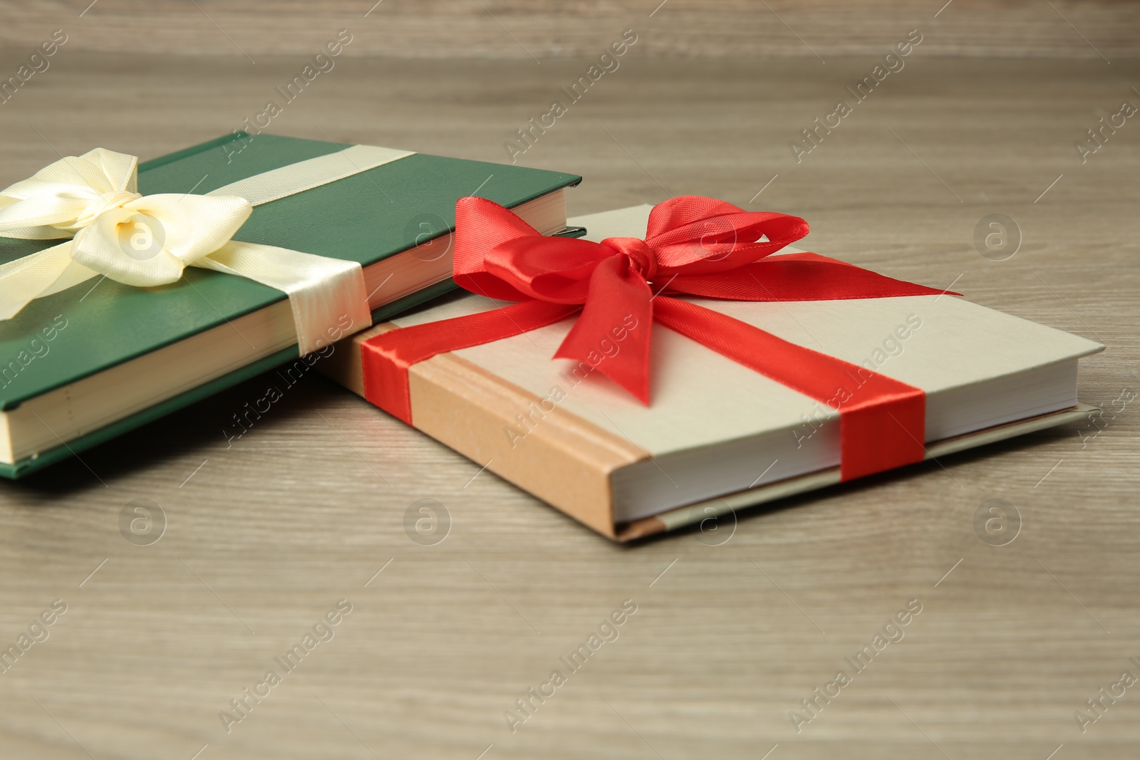 Photo of Books with ribbons as gift on wooden table