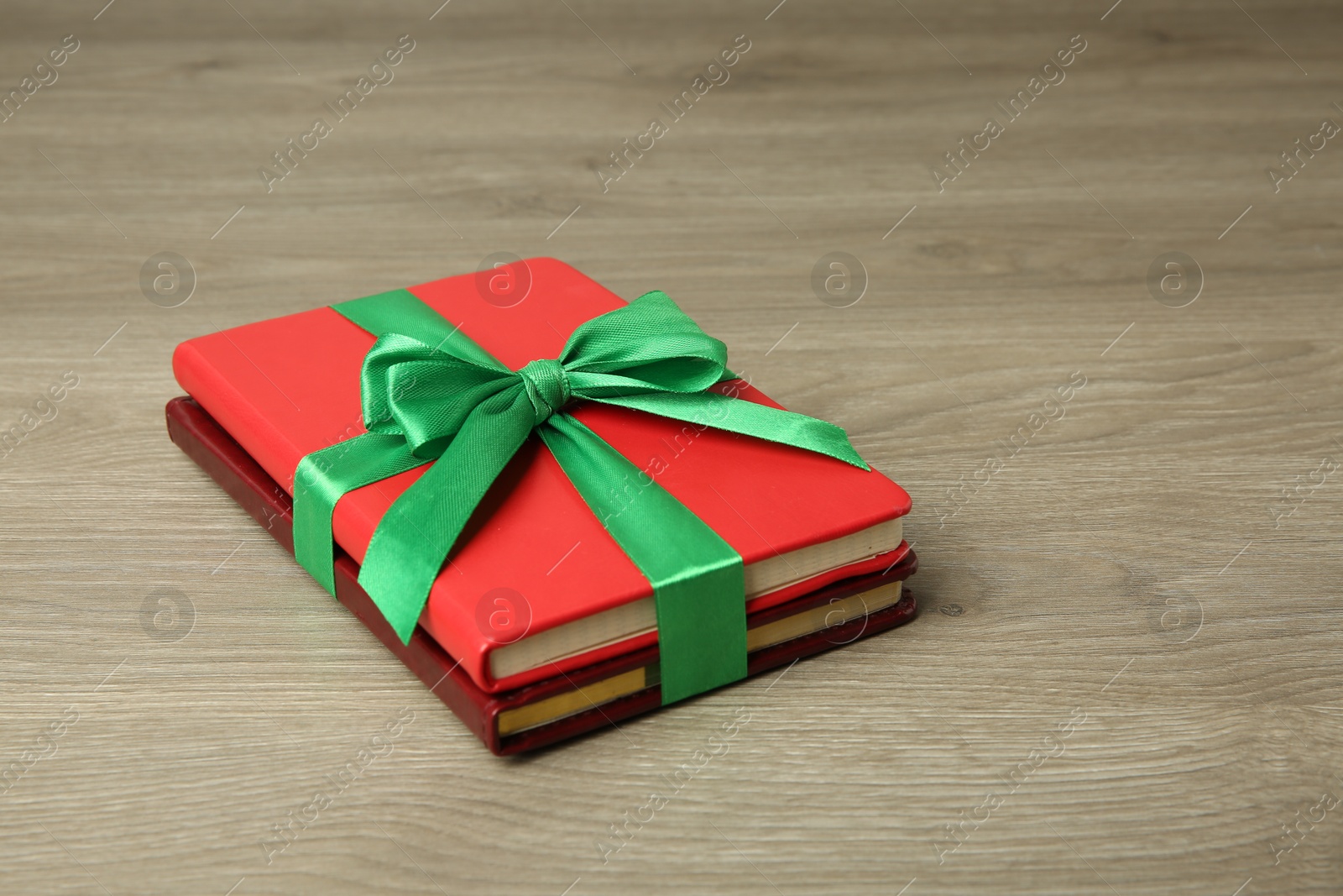 Photo of Books with ribbon as gift on wooden table