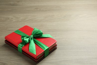 Photo of Books with ribbon as gift on wooden table, space for text