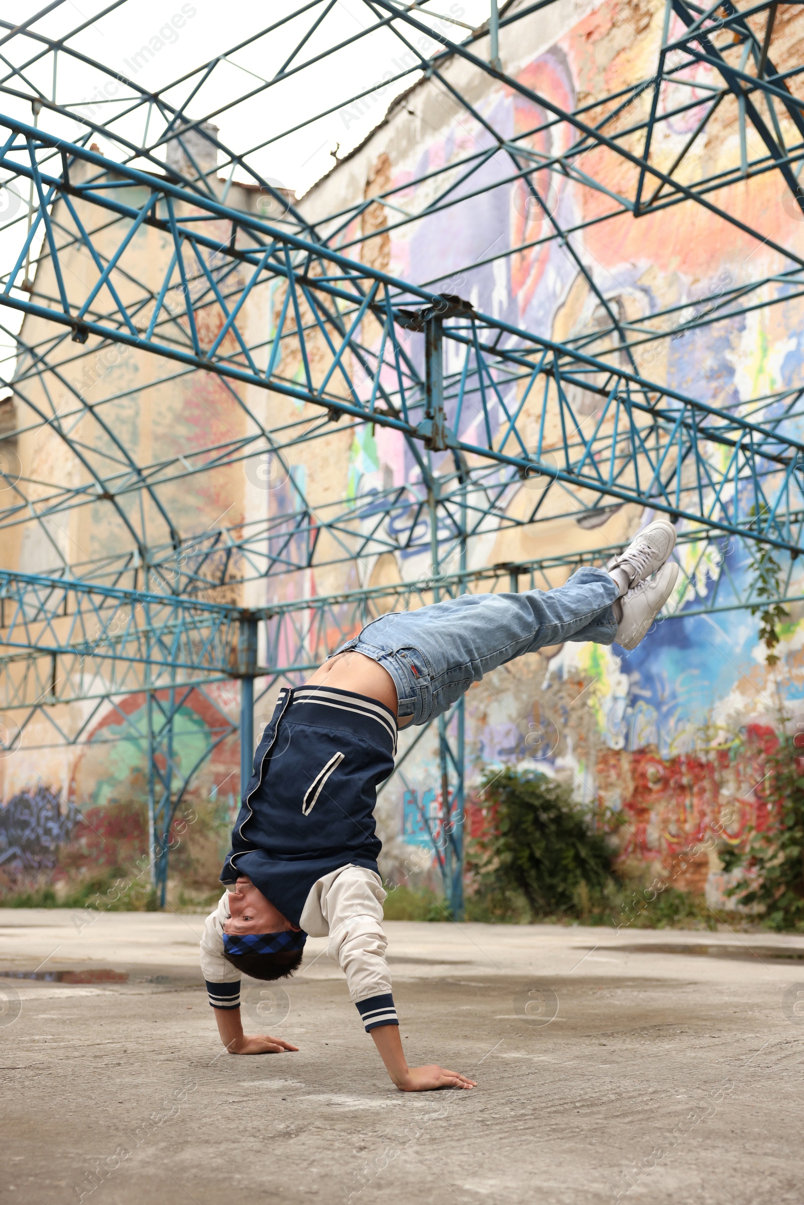 Image of Man doing handstand outdoors. Hip hop dancer