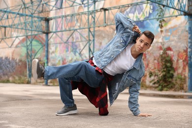 Image of Young man dancing hip hop outdoors. Street dancer