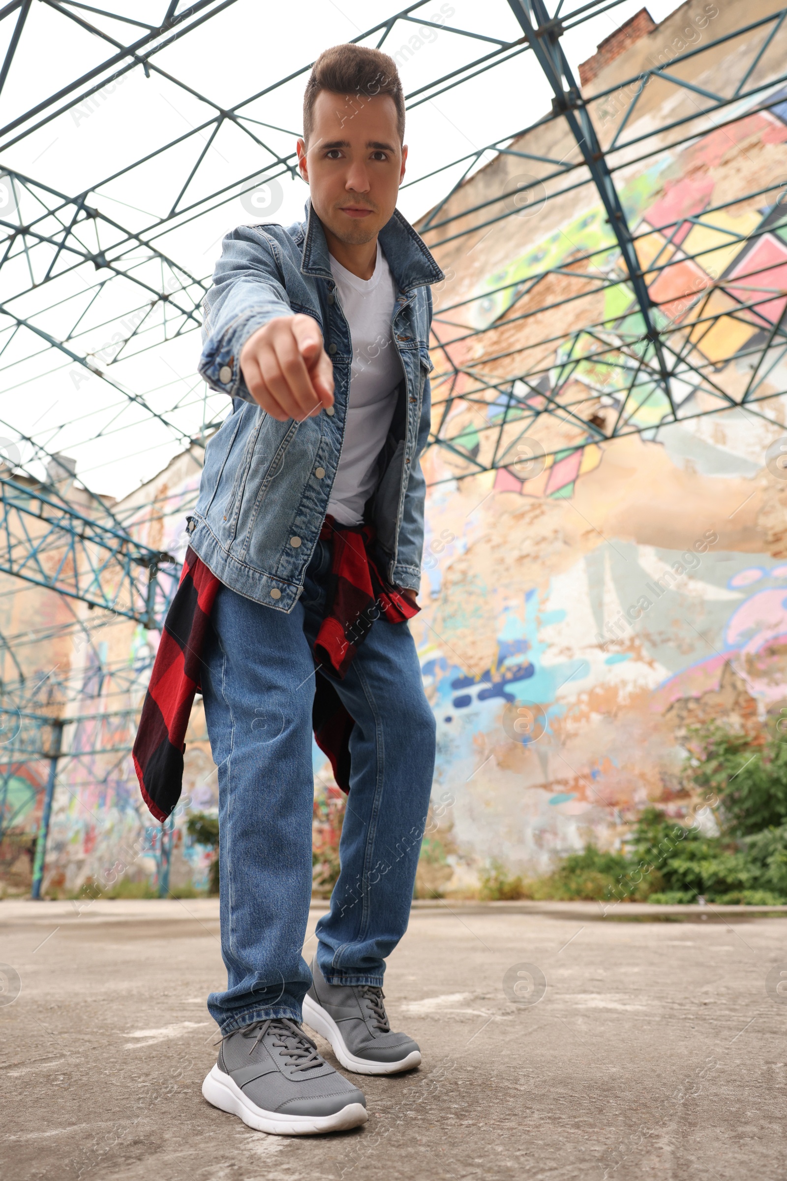 Image of Portrait of young man outdoors, low angle view. Hip hop dancer