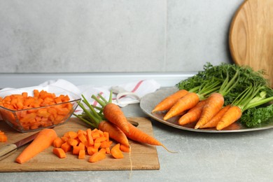 Photo of Fresh carrots and knife on gray textured table in kitchen