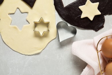 Photo of Raw doughs and cookie cutters on light table, flat lay