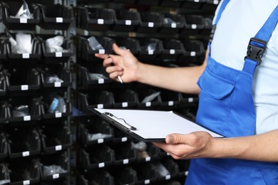 Photo of Man with clipboard and pen in auto store, closeup