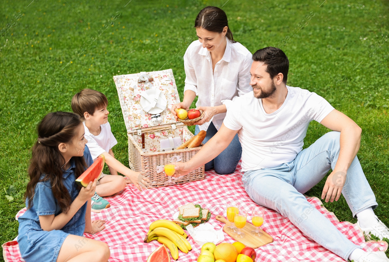 Photo of Happy family having picnic together in park