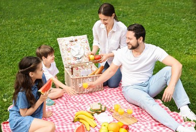 Happy family having picnic together in park