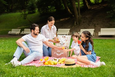 Happy family having picnic together in park