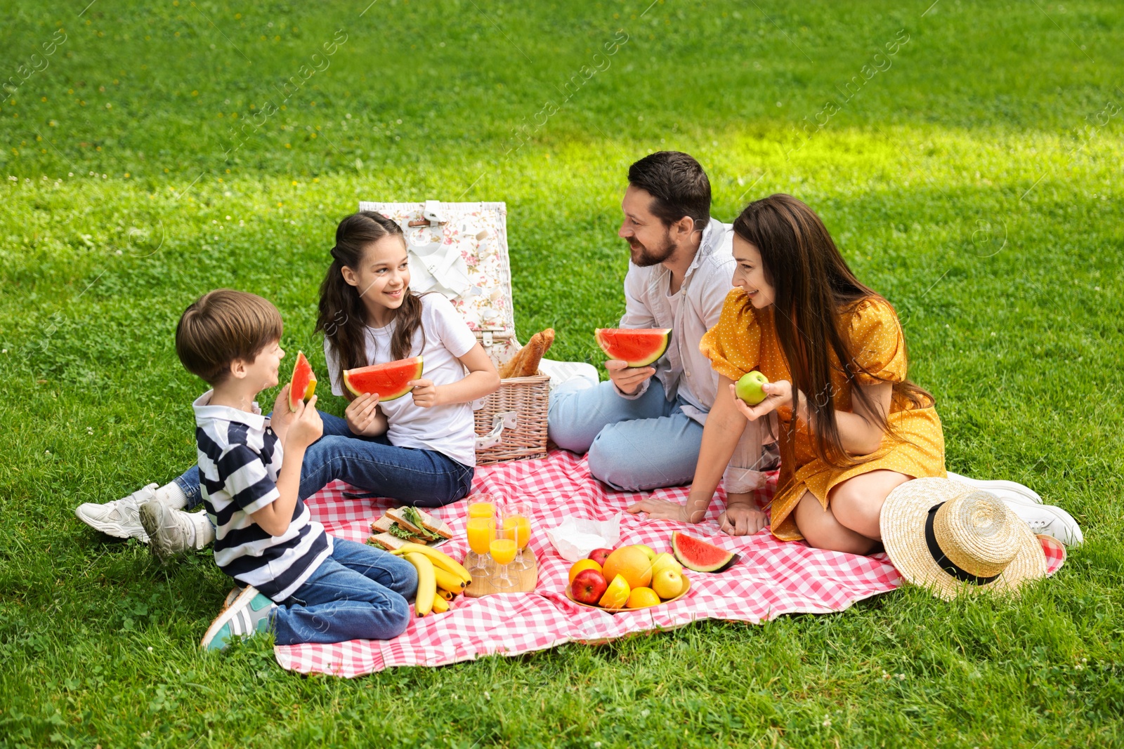 Photo of Happy family having picnic together in park