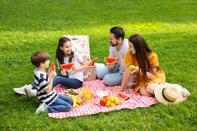 Happy family having picnic together in park