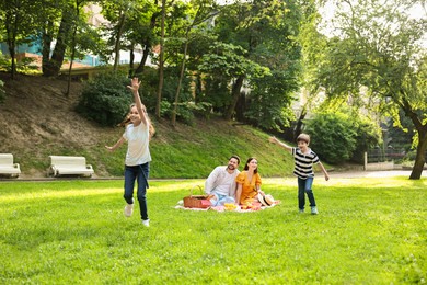 Photo of Happy children playing during family picnic outdoors