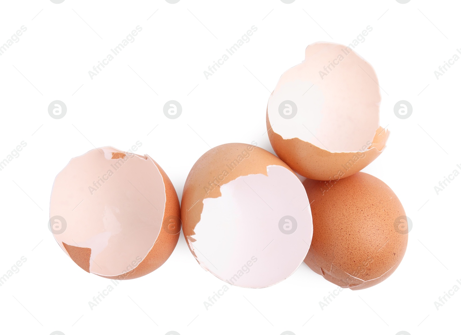 Photo of Pieces of broken eggshells isolated on white, top view