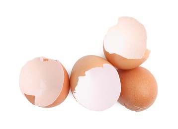 Photo of Pieces of broken eggshells isolated on white, top view