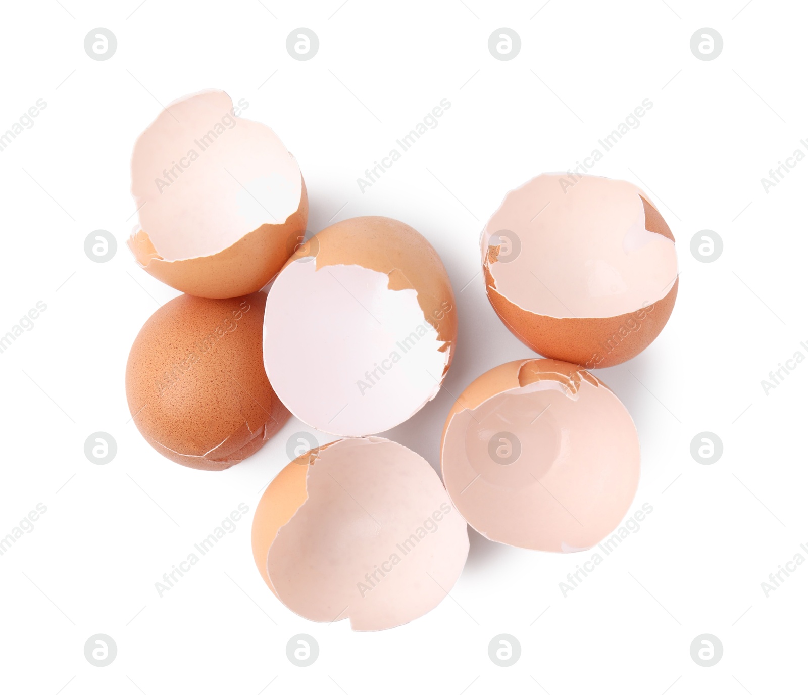 Photo of Pieces of broken eggshells isolated on white, above view