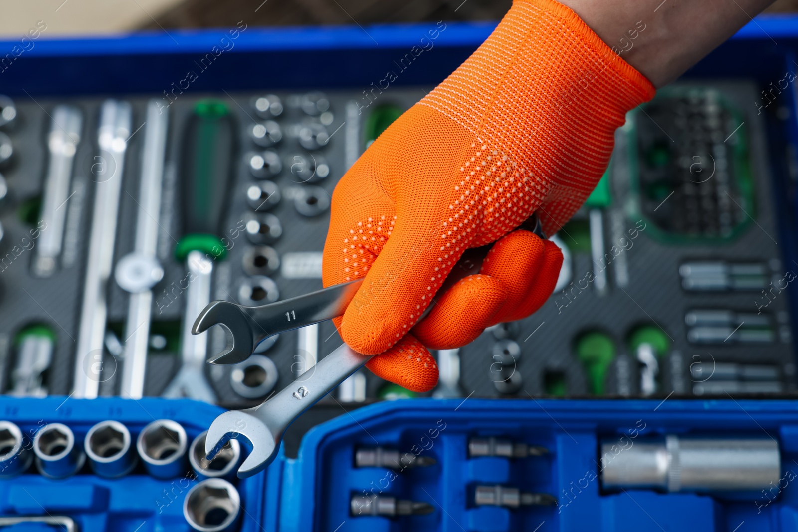 Photo of Auto mechanic with ratcheting wrenches at automobile repair shop, closeup