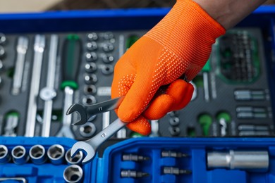 Photo of Auto mechanic with ratcheting wrenches at automobile repair shop, closeup