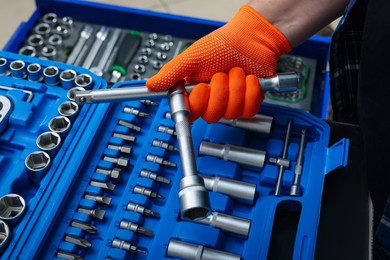 Photo of Auto mechanic with different tools at automobile repair shop, closeup